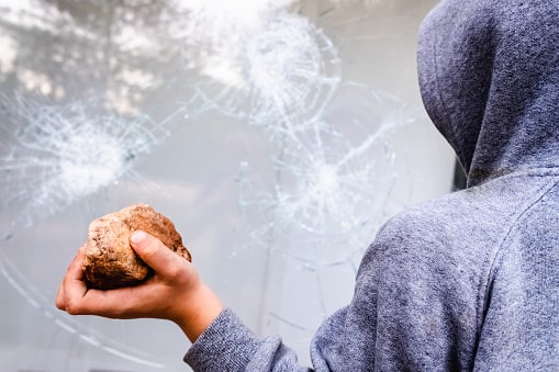vandalismo in adolescenza - un ragazzo che tira una pietra