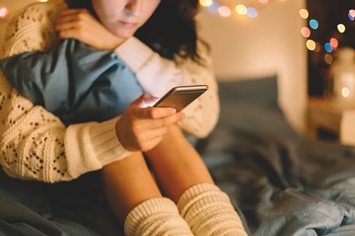 dipendenza da internet in adolescenza, adolescenti e internet - una ragazza che guarda il telefono